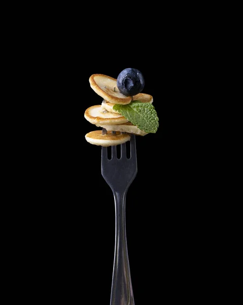 暗い背景にフォークの上に果実と小さなパンケーキ — ストック写真
