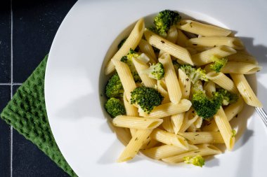 Siyah arkaplanda brokoli olan makarna..