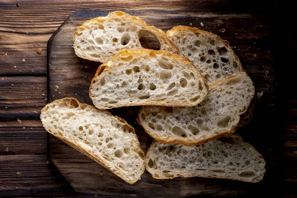 Brot Scheiben Auf Einem Brett Auf Einem Holztisch Ansicht Von lizenzfreie Stockfotos