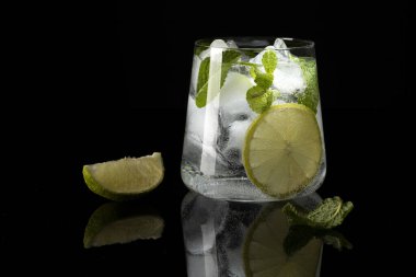 Siyah arkaplanda yansımalı mojito kokteyli..