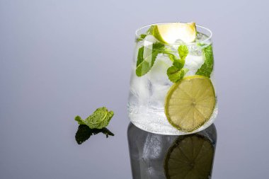 Siyah arkaplanda yansımalı mojito kokteyli..
