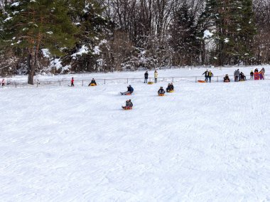 Maykop, Adygea Cumhuriyeti, Rusya Federasyonu, 01. - 24. 2021: Dağlarda aile tatili, dondurucu kış sabahı, kar motosikleti ve şişme kızak, yeni yıl tatili.