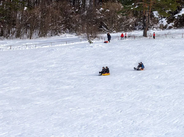 Maykop, Adygea Cumhuriyeti, Rusya Federasyonu, 01. - 24. 2021: Dağlarda aile tatili, dondurucu kış sabahı, kar motosikleti ve şişme kızak, yeni yıl tatili.
