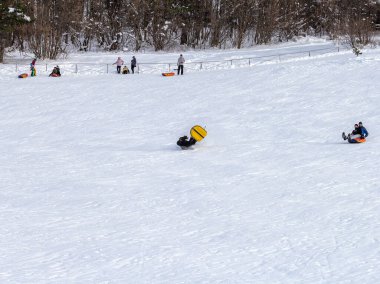 Maykop, Adygea Cumhuriyeti, Rusya Federasyonu, 01. - 24. 2021: Dağlarda aile tatili, dondurucu kış sabahı, kar motosikleti ve şişme kızak, yeni yıl tatili.