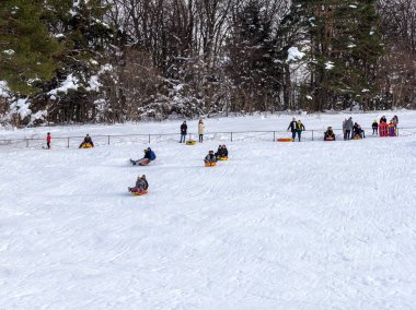 Maykop, Adygea Cumhuriyeti, Rusya Federasyonu, 01. - 24. 2021: Dağlarda aile tatili, dondurucu kış sabahı, kar motosikleti ve şişme kızak, yeni yıl tatili.