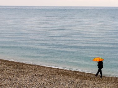 Deniz kenarında yürümek, bulutlu bir günde, doğayla iletişim, deniz havasıyla çevre dostu nefes alma prosedürleri..