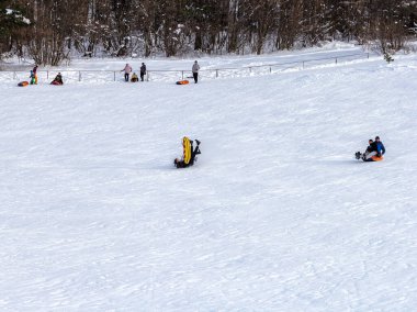 Maykop, Adygea Cumhuriyeti, Rusya Federasyonu, 01. - 24. 2021: Dağlarda aile tatili, dondurucu kış sabahı, kar motosikleti ve şişme kızak, yeni yıl tatili.