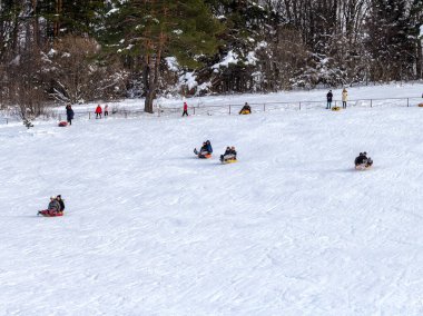 Maykop, Adygea Cumhuriyeti, Rusya Federasyonu, 01. - 24. 2021: Dağlarda aile tatili, dondurucu kış sabahı, kar motosikleti ve şişme kızak, yeni yıl tatili.