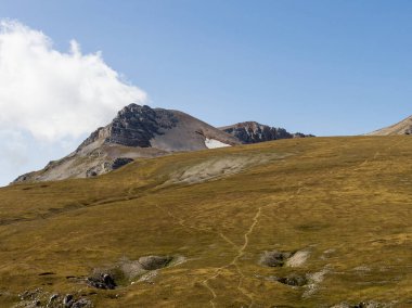 Sıcak, güneşli bir sonbahar gününde dağların dağlık alandaki yürüyüş patikalarından doğayla yürüme ve iletişim kurma panoramik manzarası..