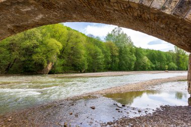 Taş köprü, bir dağ nehrinin yatağı boyunca park alanı güneşli bir yaz gününde yürüyüş..