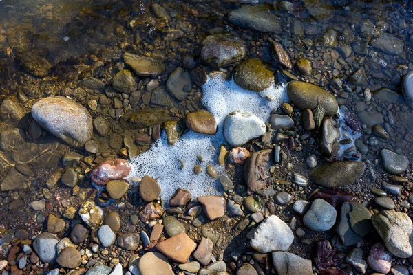 Sonbahar, sabah güneşinin altında, bir dağ nehrinin sığ kumlu dibi, yakın çekim..