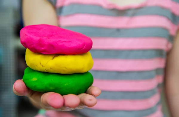 Colorful play dough on hand — Stock Photo, Image