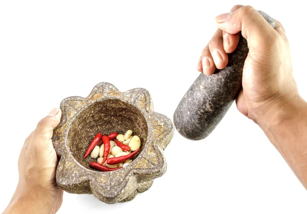Alho e pimenta vermelha em argamassa de pedra com mão segurando — Fotografia de Stock