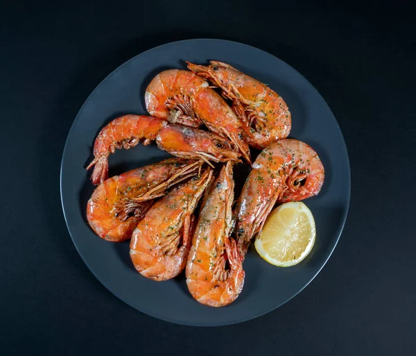 Siyah arka planda ızgara karides tabağı