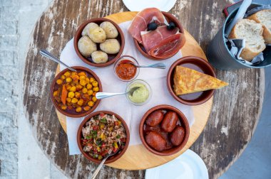 Açık bir terasta altı tapas yemek.