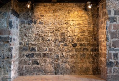 Stone wall of a church interior with spotlights illuminating