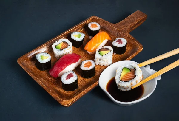 Maki Papan Sushi Dengan Mangkuk Kedelai Dan Sumpit Mencelupkan Sepotong — Stok Foto