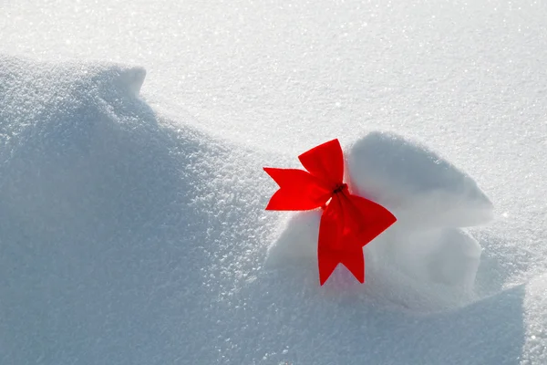 Rote Schleife auf Schnee Hintergrund — Stockfoto