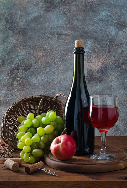 Flasche Und Glas Rotwein Trauben Und Apfel Auf Holztisch lizenzfreie Stockbilder