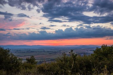 Güzel yeşil tepeler ve yeşil vadi. Küçük uyuyan kasaba. Renkli bir gökyüzü, kırmızı bulutlar. Sisin içindeki dağlar. Güneş doğmadan önce. Carpathian, Ukrayna, Avrupa. Güzellik dünyası.