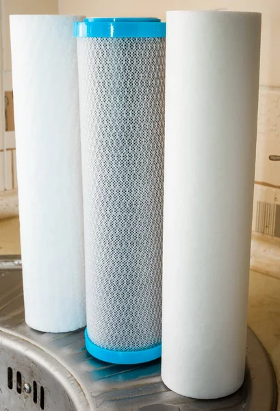 New reverse osmosis system cartridges on a kitchen background. Elements of a filtration system for clean and healthy water.