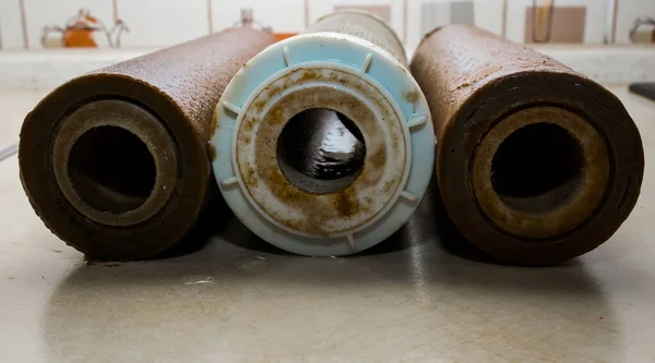 肮脏的人在厨房背景上使用反渗透系统弹药筒 清洁和健康用水过滤系统的要素 — 图库照片