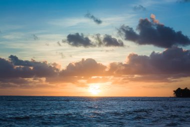 Denizde güzel bir gün doğumu. Atlantik Okyanusu 'nda şafak vakti. Güneş, denize yansıyor. Doğan güneşin arka planında palmiye ağaçları. Tropik gün doğumu. Dominik Cumhuriyeti