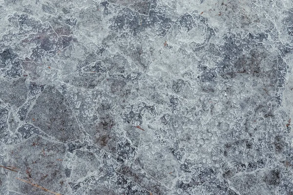 黄色の葉でコンクリートに砕いた氷 黄色の葉とコンクリートは割れた氷の下で見ることができます — ストック写真