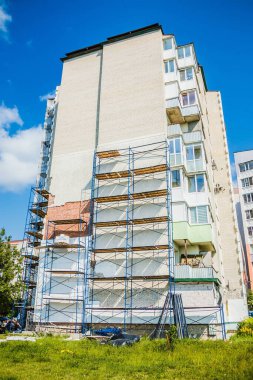 Eski apartman iskelesi yenilenmiş bina cephesi ayrıntıları. Evin duvarlarında iskele iskelesi var. Yeniden Yapılandırma