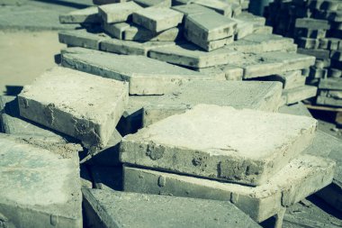 Parçalanmış asfalt levhalar ya da kaldırım taşları, alanın ortasındaki paletlerin üzerine istiflenmiş kaldırma ve seçici odaklanma için bekliyor.