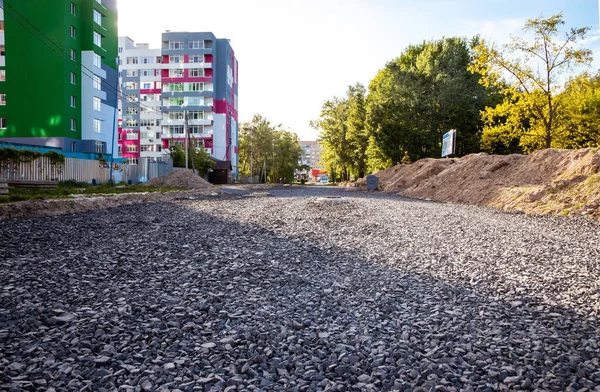 Road from rubble in the city near the construction of new houses.