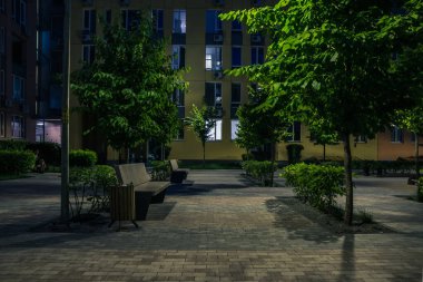 Night park paths and colored houses at summer night. Night paths, benches and lanterns in a beautiful residential complex. Night summer park with lanterns and benches. Kyiv. Ukraine