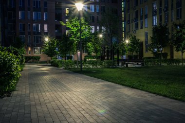 Night park paths and colored houses at summer night. Night paths, benches and lanterns in a beautiful residential complex. Night summer park with lanterns and benches. Kyiv. Ukraine