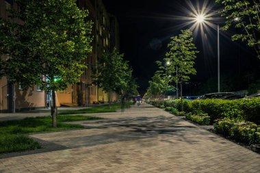Night park paths and colored houses at summer night. Night paths, benches and lanterns in a beautiful residential complex. Night summer park with lanterns and benches. Kyiv. Ukraine