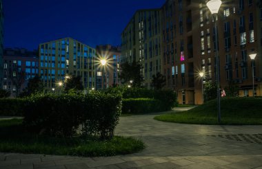 Night park paths and colored houses at summer night. Night paths, benches and lanterns in a beautiful residential complex. Night summer park with lanterns and benches. Kyiv. Ukraine