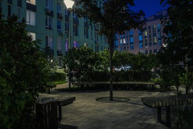 Night park paths and colored houses at summer night. Night paths, benches and lanterns in a beautiful residential complex. Night summer park with lanterns and benches. Kyiv. Ukraine
