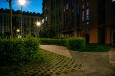 Night park paths and colored houses at summer night. Night paths, benches and lanterns in a beautiful residential complex. Night summer park with lanterns and benches. Kyiv. Ukraine