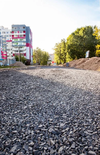 Road from rubble in the city near the construction of new houses.