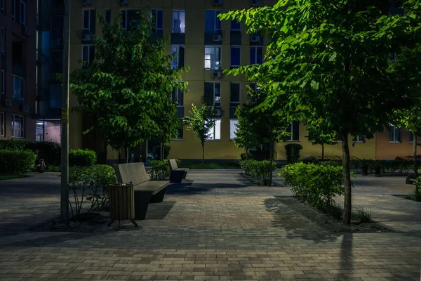 Night park paths and colored houses at summer night. Night paths, benches and lanterns in a beautiful residential complex. Night summer park with lanterns and benches. Kyiv. Ukraine