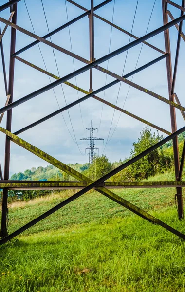 High voltage, power transmission line on the mountain range. Overhead power line in the mountains. Metal poles of power lines in the mountains