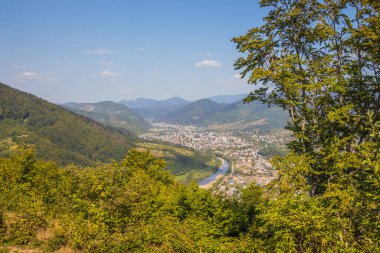 Bir yaz günü yüksek bir dağdan dağlarla nehir ve köy arasında bir vadiye bak. Tepeleri, dağları, vadiyi, nehri ve köyü gözleyin. Karpatlar. Ukrayna