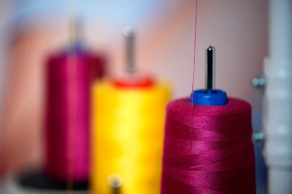 Yellow and pink reels of thread at tailor's — Stock Photo, Image