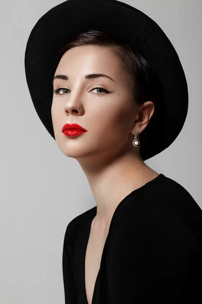 Portrait of a young girl in a black hat — Stock Photo, Image