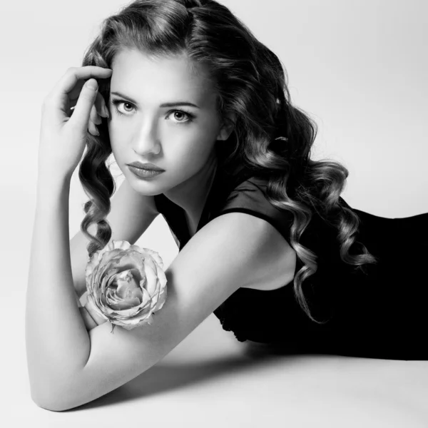 Retrato en blanco y negro de una linda chica con una rosa en las manos — Foto de Stock