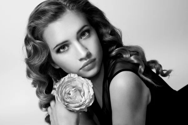 Retrato en blanco y negro de una linda chica con una rosa en las manos — Foto de Stock