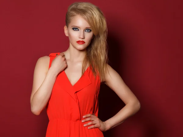 Fashionable beautiful girl in a red dress. Blonde hair and red l — Stock Photo, Image