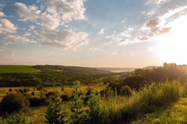 Sunset over hills and green fields in summer