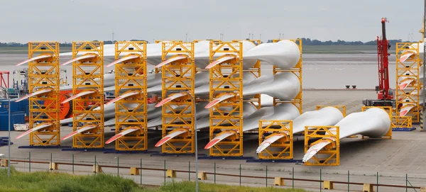 Vele rotorbladen voor grote windturbines in haven Stockfoto