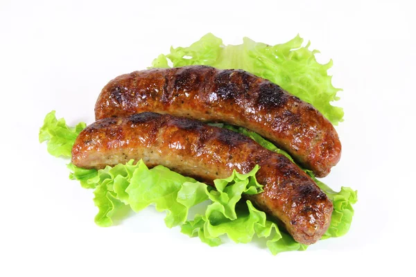 Two tasty grilled sausage with lettuce isolated — Stock Photo, Image