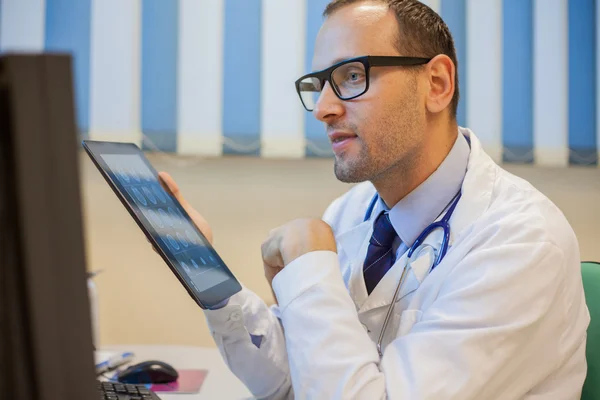 Un medic de serviciu care lucrează în ficatul său pe un computer (PC) și — Fotografie, imagine de stoc